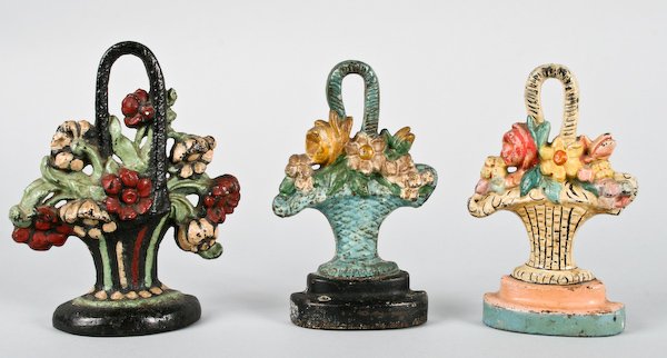 Three Vintage Cast Iron Flower Basket Doorstops: American School, 20th Century, Three Vintage Cast Iron Flower Basket Doorstops, ranging in size from 8-1/4 to 9 inches (height). Provenance: The Betty Gordon Estate.