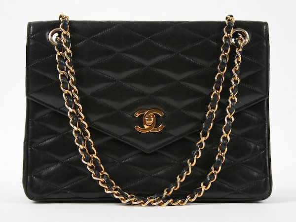 Chanel Quilted Black Leather Flap Bag: Chanel Quilted Black Leather Flap Bag, with red leather interior, double strap and gold hardware, original storage bag and box, 7 x 9-3/4 x 3 inches. Provenance: The Betty Gordon Estate.