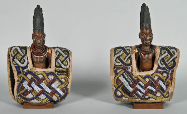 Nigerian Yoruba Wood Male Figures (ere ibeji): Pair of Nigerian Yoruba Wood Male Figures (ere ibeji) in Elaborately Beaded Capes with Guilloche Design, with Necklaces, Tall Coiffures and Nail eyes, each approximately 12 inches tall. $800-1200.