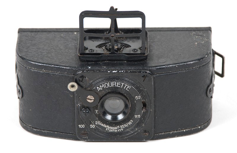 Amourette Roll Film Camera: Amourette Camera (Serial No. 002028) with Double Miniscope Lens. Manufactured by O.T.A.G in Vienna, Austria. Includes Vintage Advertisement. Provenance: The Kaprelian Camera Collection, Philadelphia, 