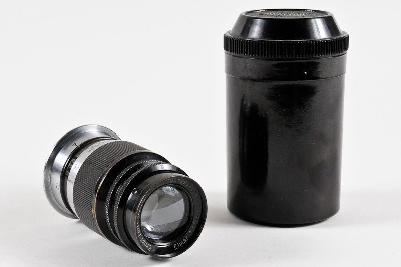 Leica Elmar f/4 9cm Screw-Mount Lens: Leica Elmar f/4 9cm Screw-Mount Lens (Serial No. 165470), Black/Nickel with a Bakelite Lens Case. Manufactured by Ernst Leitz in Wetzlar, Germany. Provenance: The Kaprelian Camera Collection, Philadel