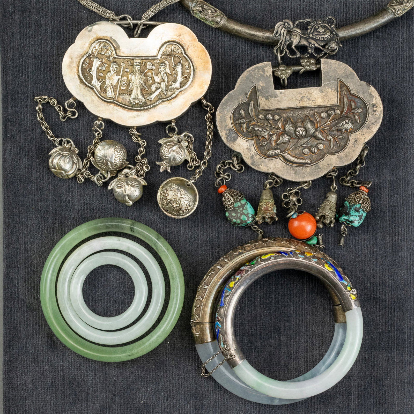 A Group of Five Chinese Jade and Hardstone Bangles and Two Silver and Hardstone Necklaces: The bangles of celadon green, two with silver and enamel halves; two Chinese ceremonial necklaces each of silver, one with malachite, coral, turquoise and bone beading, with figural and floral designs