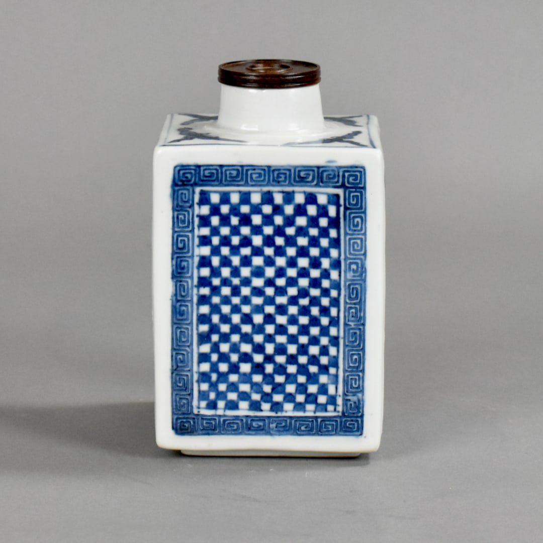 Chinese Export Blue and White Porcelain Tea Caddy: 19th century, of squared section raised on a low foot rim, painted on each side with a checkerboard pattern within molded key-fret borders, the shoulders with dragonflies, base with an artemisia mark 