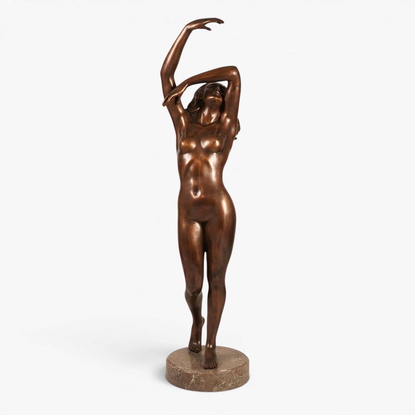 Large Bronze Sculpture Depicting a Female Nude: 20th century, posed reaching upward with the left elbow bent over the face, mounted on a circular light grey/brown mottled stone base, unsigned The collection of Frank and Irene Giuffrida, owners of