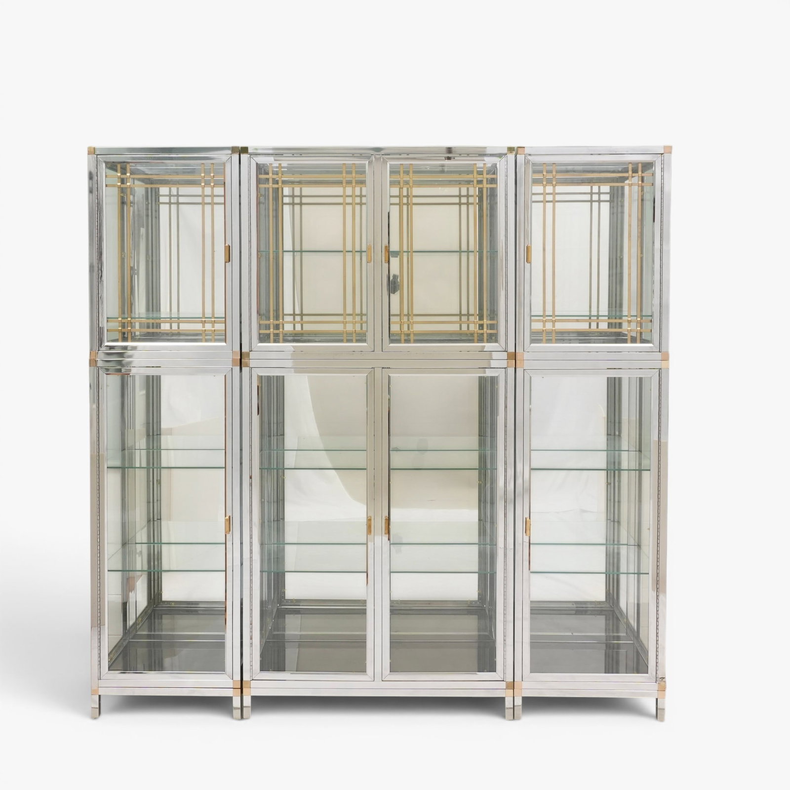 Vintage Edoardo Orlandi Style Steel & Brass Vitrine Cabinet, Circa 1970's: Mid-century Hollywood Regency style chrome and glass framed six piece modular display cabinet with mirrored back, brass latticework details and glass shelves The collection of Frank and Irene Giuffrid