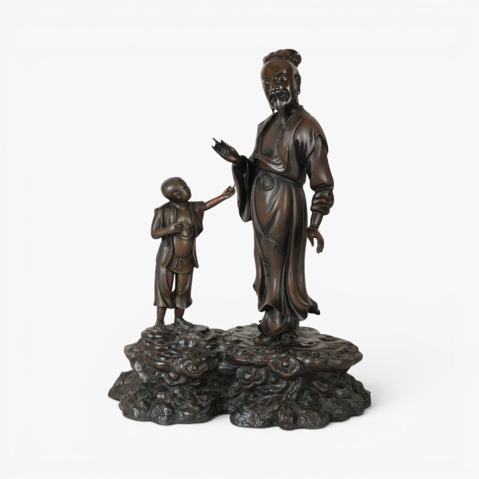 Chinese Bronze of a Scholar and Attendant: 20th century, standing on a base of scrolling clouds, the scholar dressed in a loose robe secured at the waist and gently swaying in the breeze, the boy attendant looking up towards him and reaching t