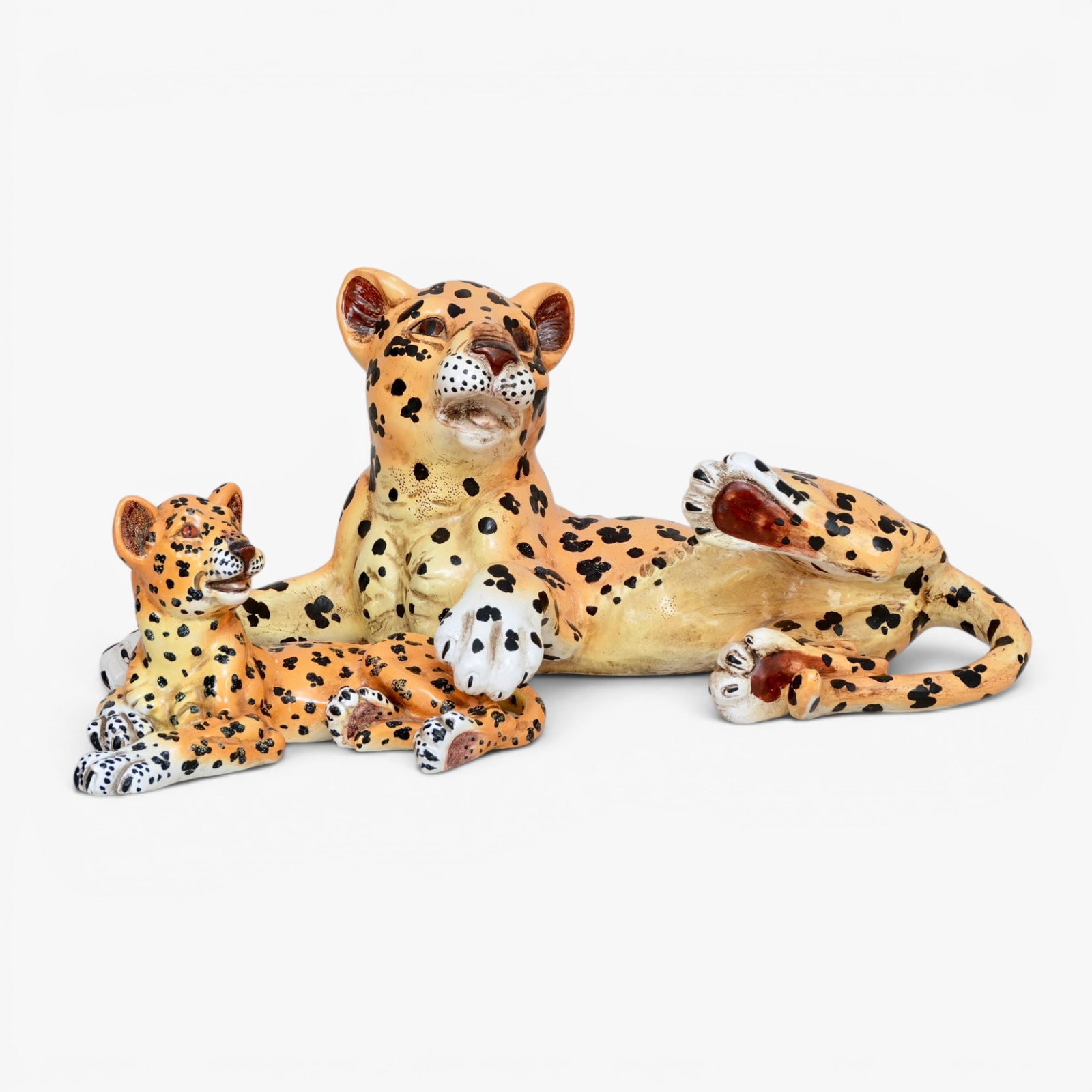 Two Vintage Italian Ceramic Leopards: Both in recumbent positions, the heads raised in a playful pose, bases marked 'Italy for Heiselman E952 and E776' The collection of Frank and Irene Giuffrida, owners of the famous Hilltop Steakhouse,