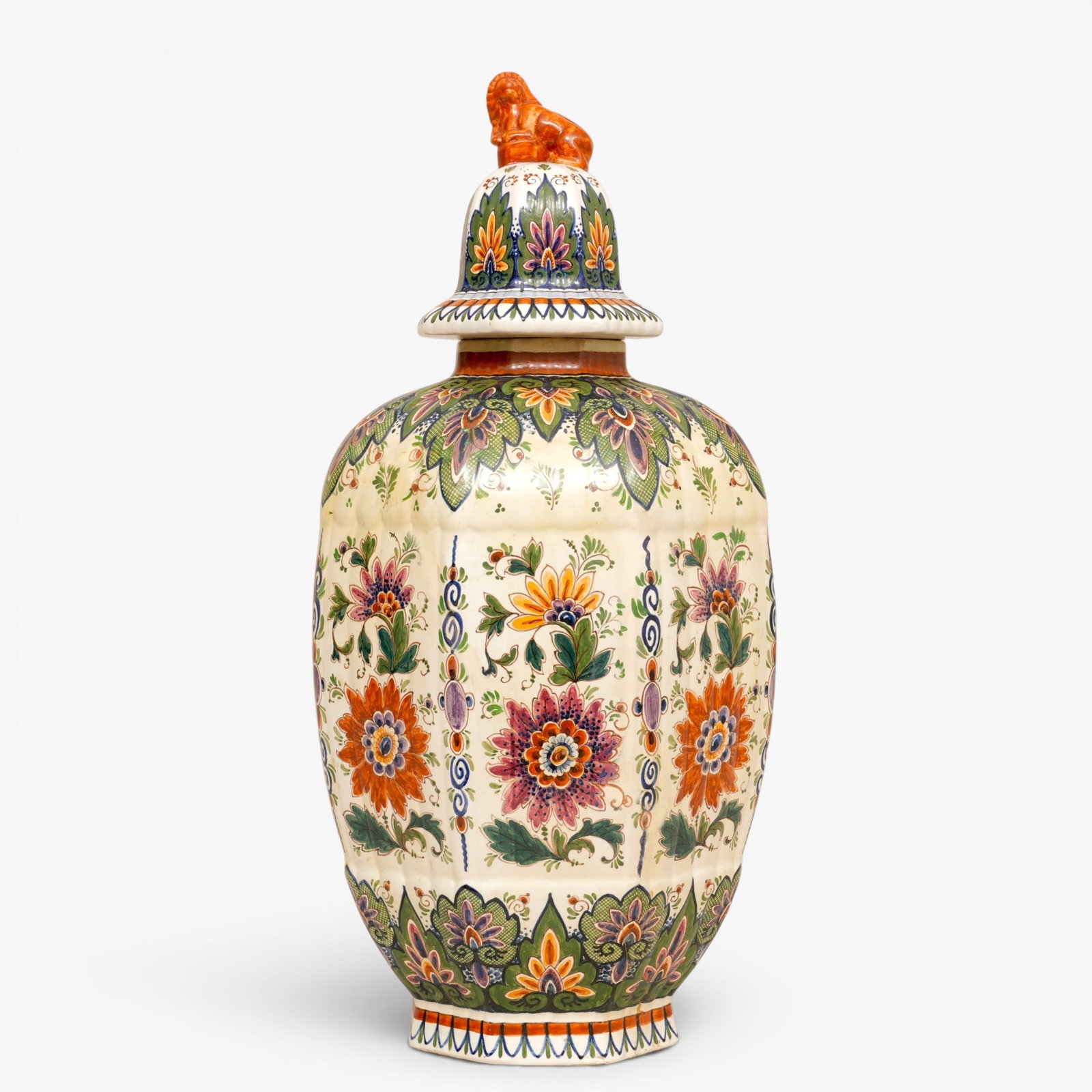 Delft Hand Painted Vase with Lid: Of octagonal section with a conforming lid with lion finial, painted with floral cartouches and stylized overlapping leaf bands at the shoulder The collection of Frank and Irene Giuffrida, owners of