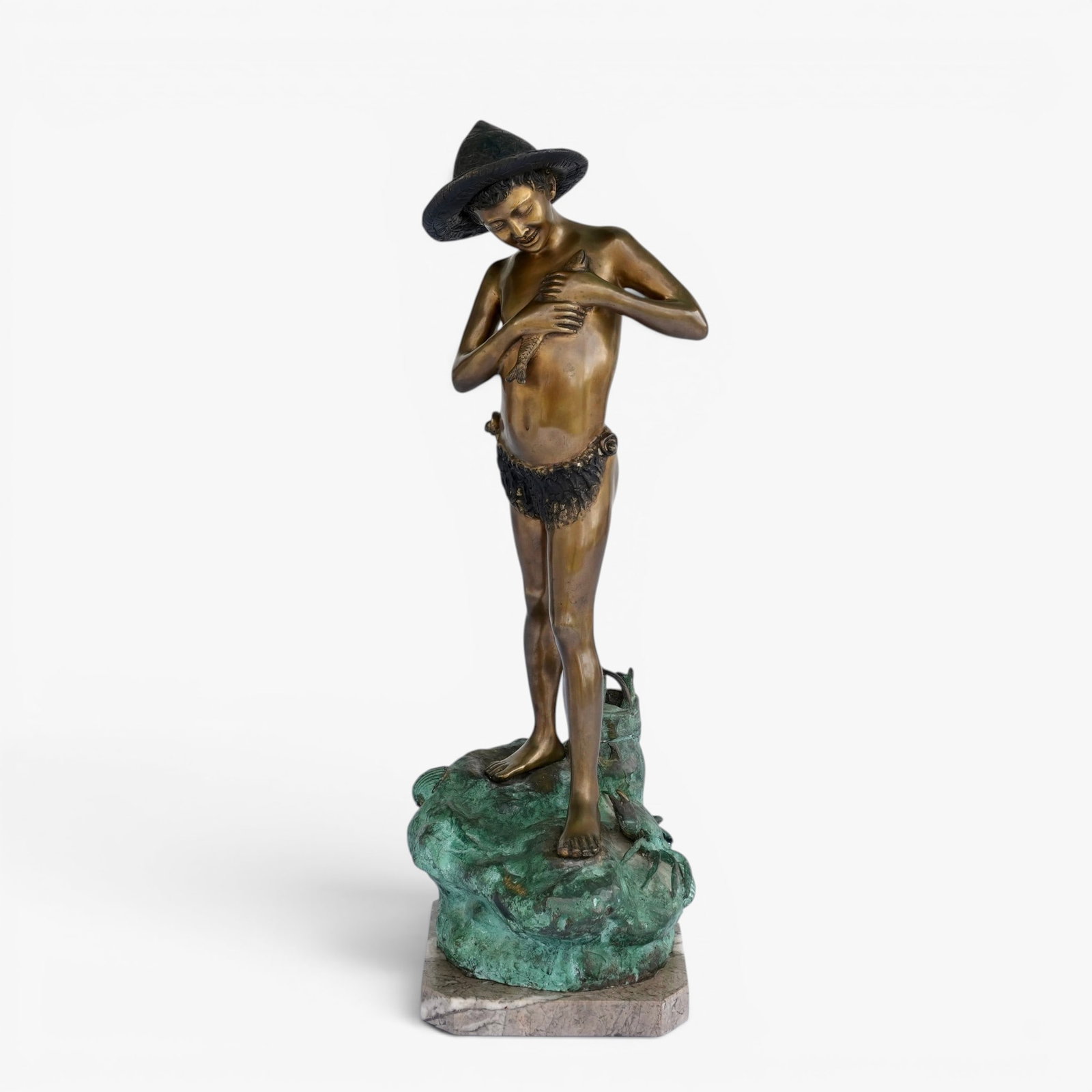 Italian Bronze Sculpture of a Young Fisherman, "Pescatorello": 20th century, after Giovanni Varlese (1882-1922), depicting a pleased young boy with brimmed hat and shorts holding a fish, with a crab and a basket of fish at his feet, standing on a naturally cast