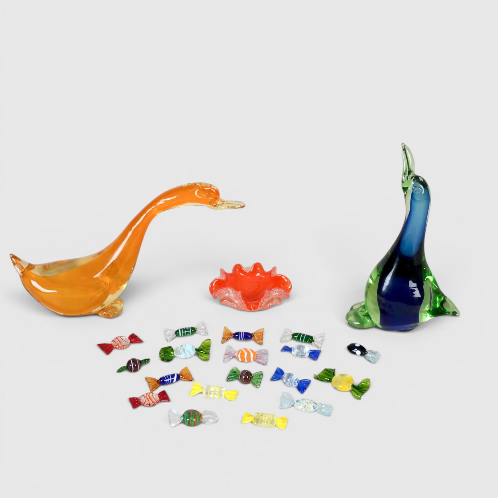 Italian Murano Glass Candy Forms, Candy Dish and Art Glass Birds: Italian Murano candy, 18 pieces; 2 art glass birds of unknown origin; Murano orange candy dish with gold flake The collection of Frank and Irene Giuffrida, owners of the famous Hilltop Steakhouse,