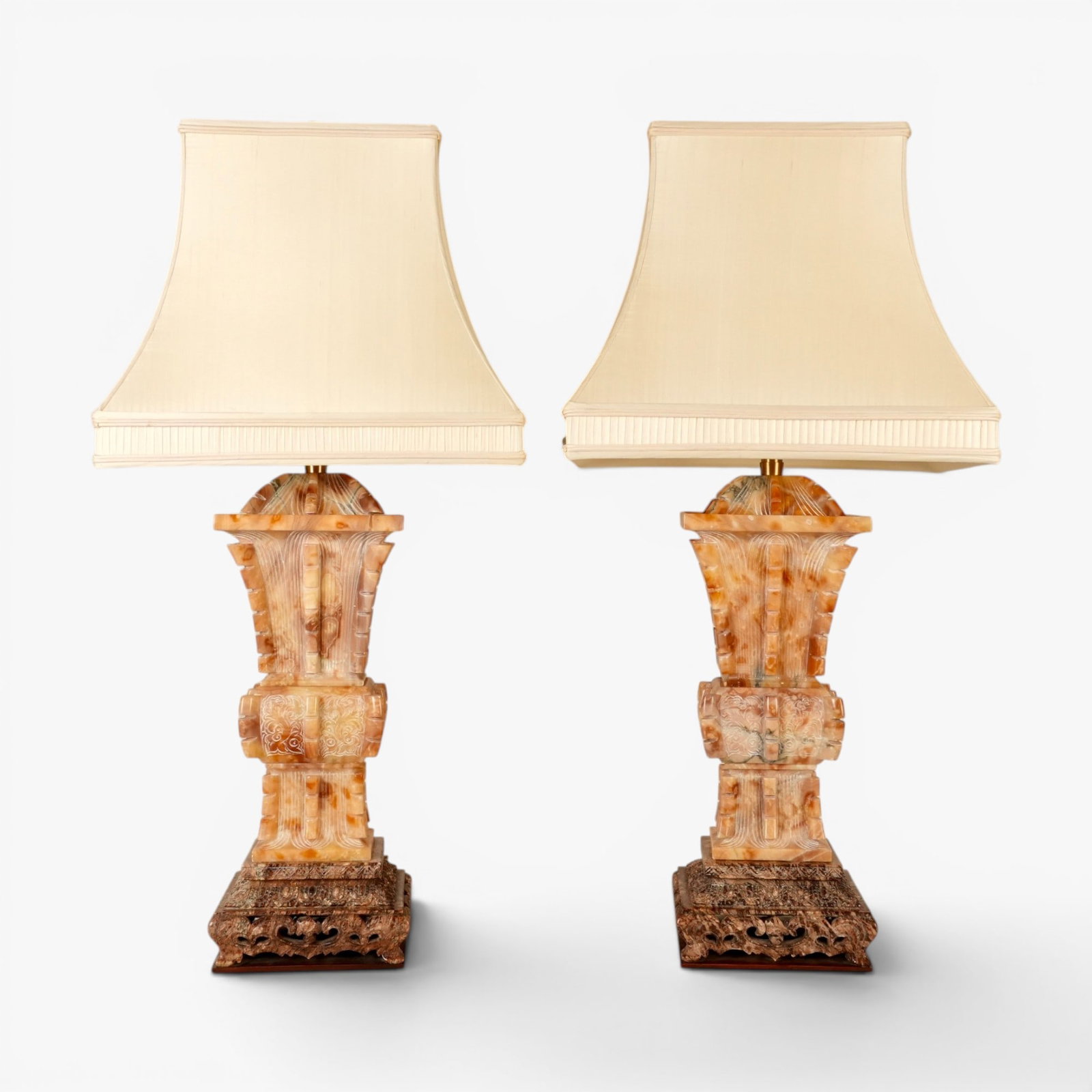 A Pair of Chinese Soapstone Archaic Form Vases Mounted as Lamps: 20th century, of lidded squared gu form, each corner with pronounced flanges dividing stylized chilong on the body and vertical lines at the neck and base, the foot carved with a leaf tip border
