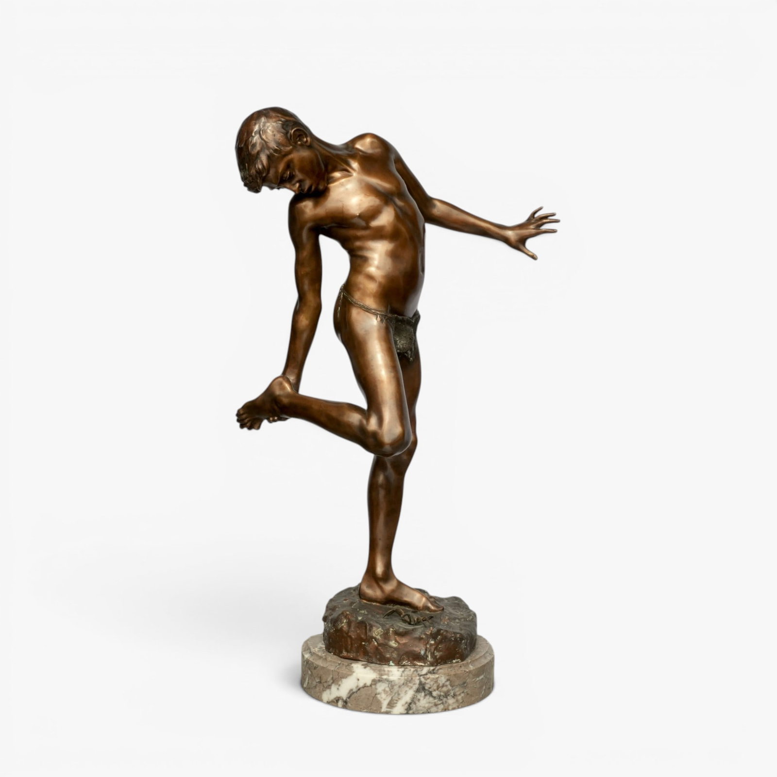 Large Italian Bronze of "Il Granchio" (the Crab): 20th century, after Annibale De Lotto, Italian, (1877-1932) cast as a small boy inspecting his foot after being pinched by a crab, deep brown patination, mounted on a light gray mottled stone base, si