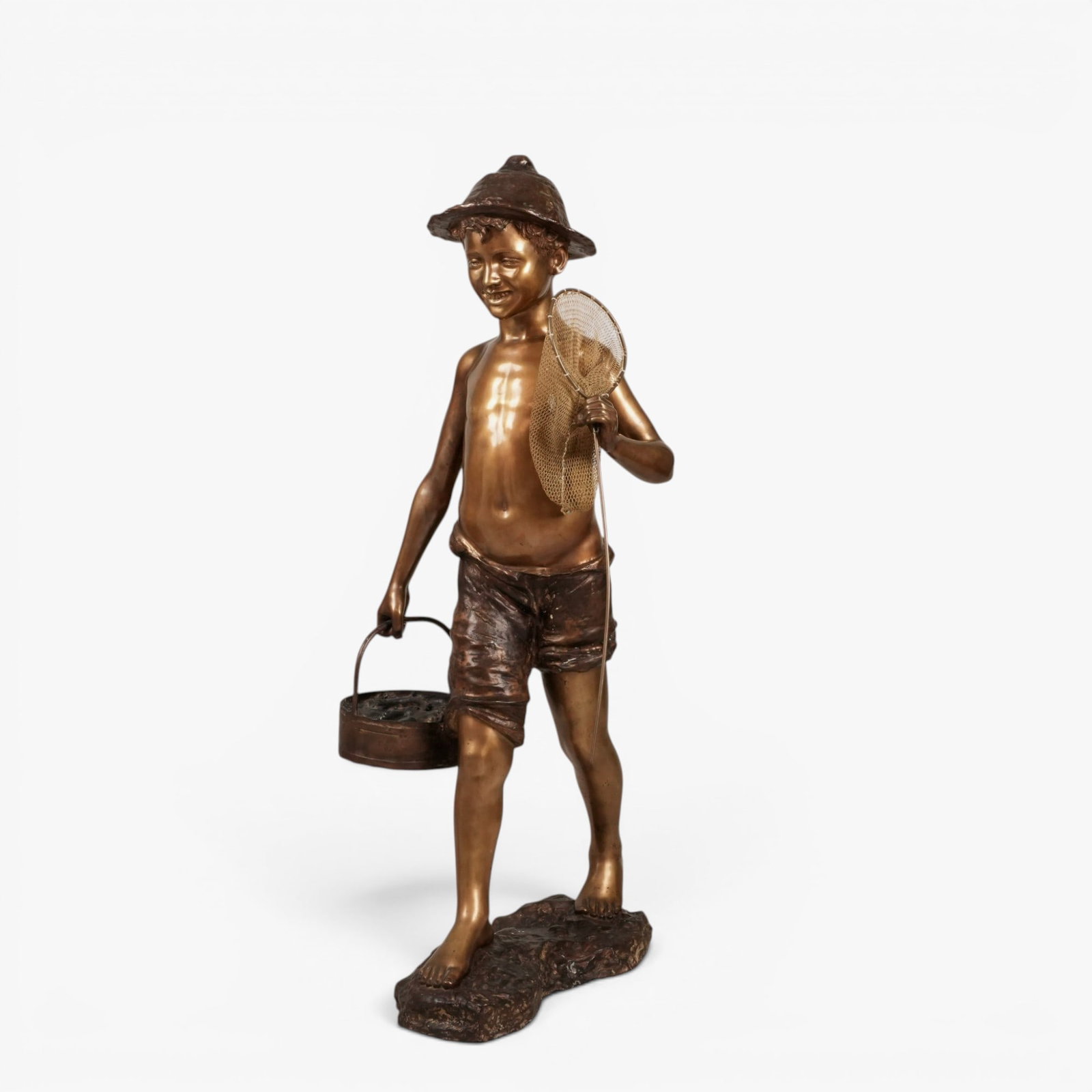 Large Bronze of "Fischerjunge" (Fisher Boy): 20th century, after Mario De Martino, Italian, (1870-1935), the young smiling boy depicted with a bucket of fish and a mesh net, base signed De Martino The collection of Frank and Irene Giuffrida, own