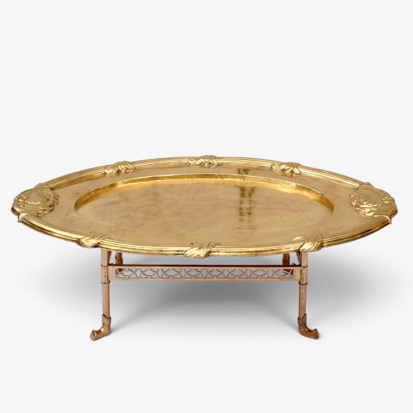Vintage Brass Coffee Table: The large oval top with scrolling details at the edges set on top of a separate rectangular stand The collection of Frank and Irene Giuffrida, owners of the famous Hilltop Steakhouse, Saugus, MA
