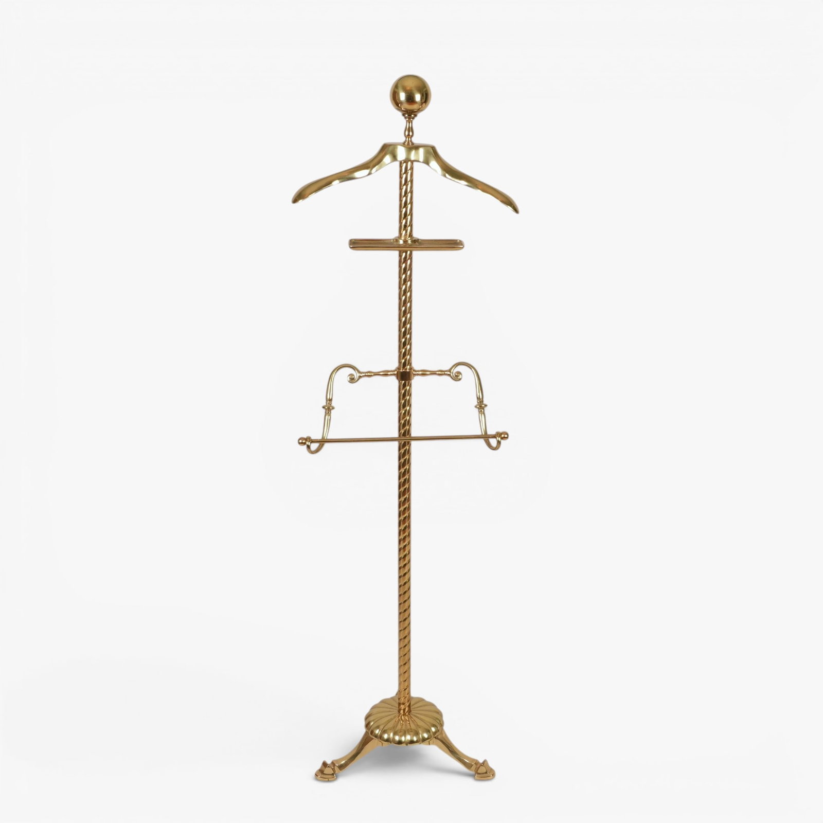 Brass Suit Rack: 20th century, the twisted rope form post rising to a ball finial, below a jacket hanger and small tray, with a pants hanger midway down, all supported by three pad feet The collection of Frank and