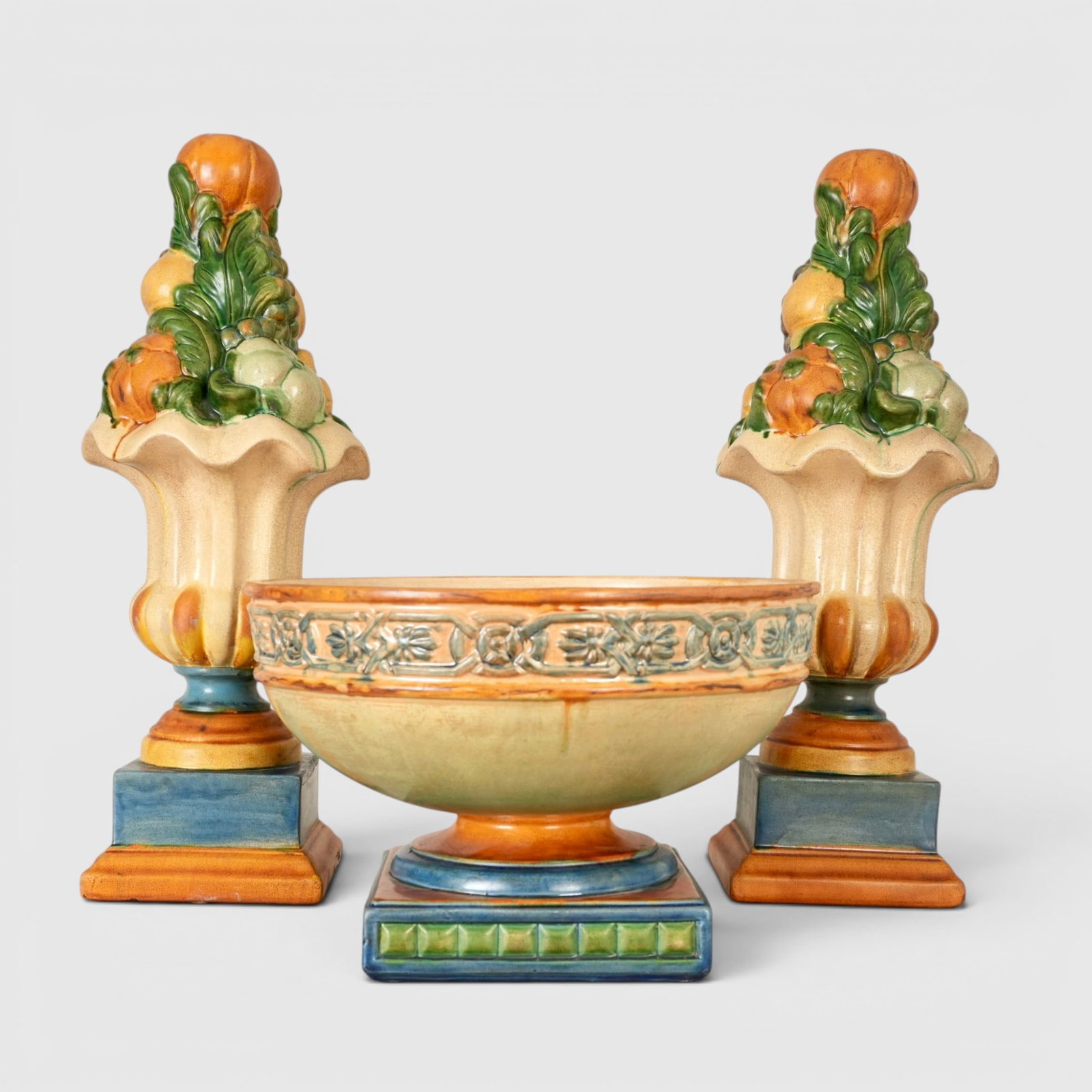 Italian Ceramic Centerpiece Bowl and Two Vases with Fruit: The bowl and vases glazed in rust, buff, blue and green, centerpiece bowl measures approx.: 8.25" tall x 13"in diameter The collection of Frank and Irene Giuffrida, owners of the famous Hilltop