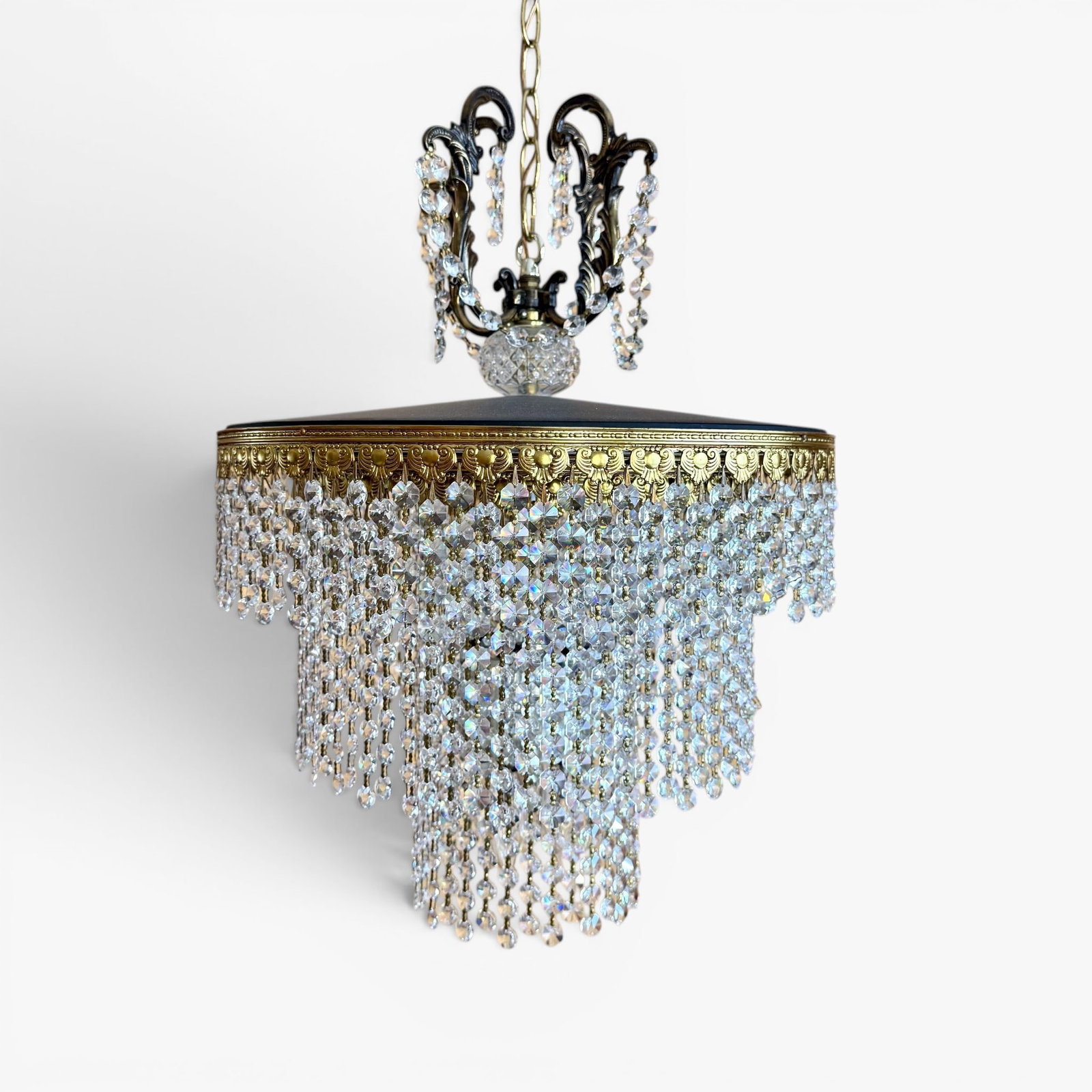 A Cascade Eight-Light Hanging Chandelier: Antique gold tone metal with glass droplets, eight lights hanging from a gold tone metal chain, height 22, diameter 16 chain length 175 inchesThe collection of Frank and Irene Giuffrida, owners of