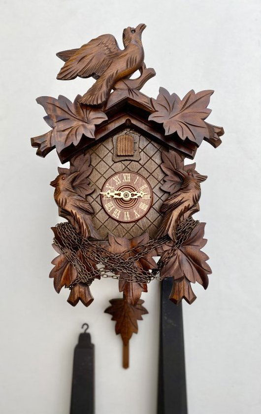 CUCKOO Clock From Germany: Cuckoo clock with birds and 5 leaves. Mechanical 1-day movement, the weights must be raised 1x per day. On the hour and half hour, the Cuckoo opens its door and cuckoos.The case is made of wood and ha