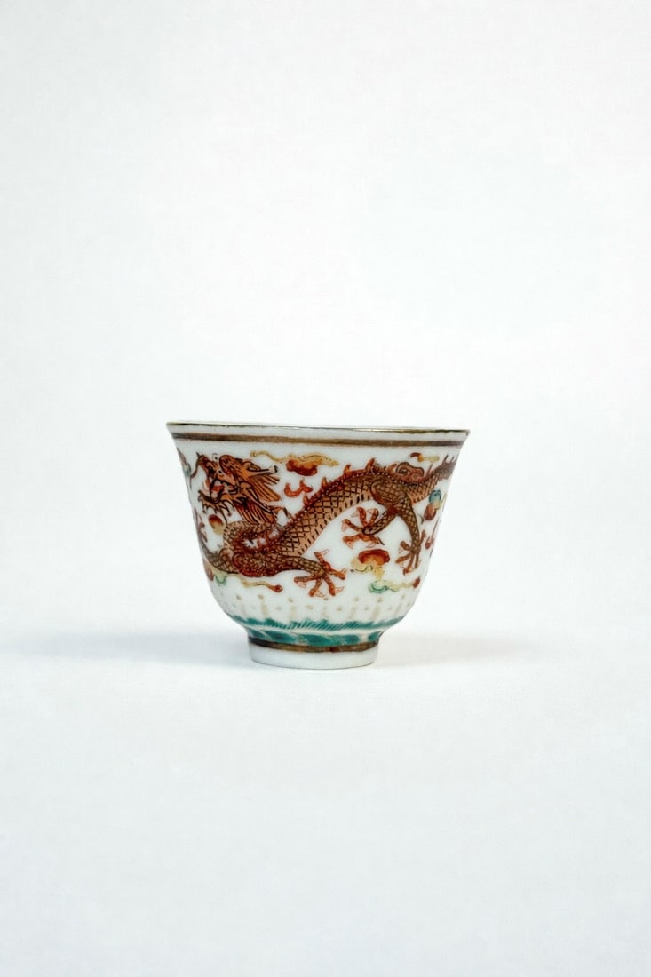 A SMALL PORCELAIN CUP, China, Qing dynasty, 19th century: h cm 4,5 Decorated all around with dragons among clouds chasing the pearl.
