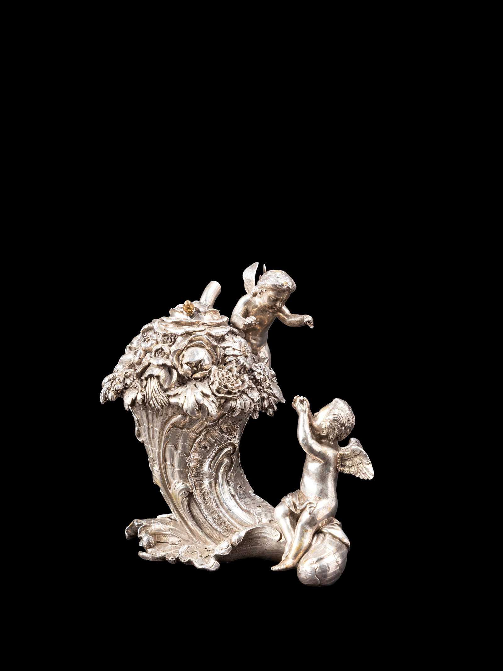 A SILVER SCULPTURE, Late 19th century: h cm 12,3 x l cm 12.Chased in the form of a cornucopia with celebrating putti. Weight: 944 g.