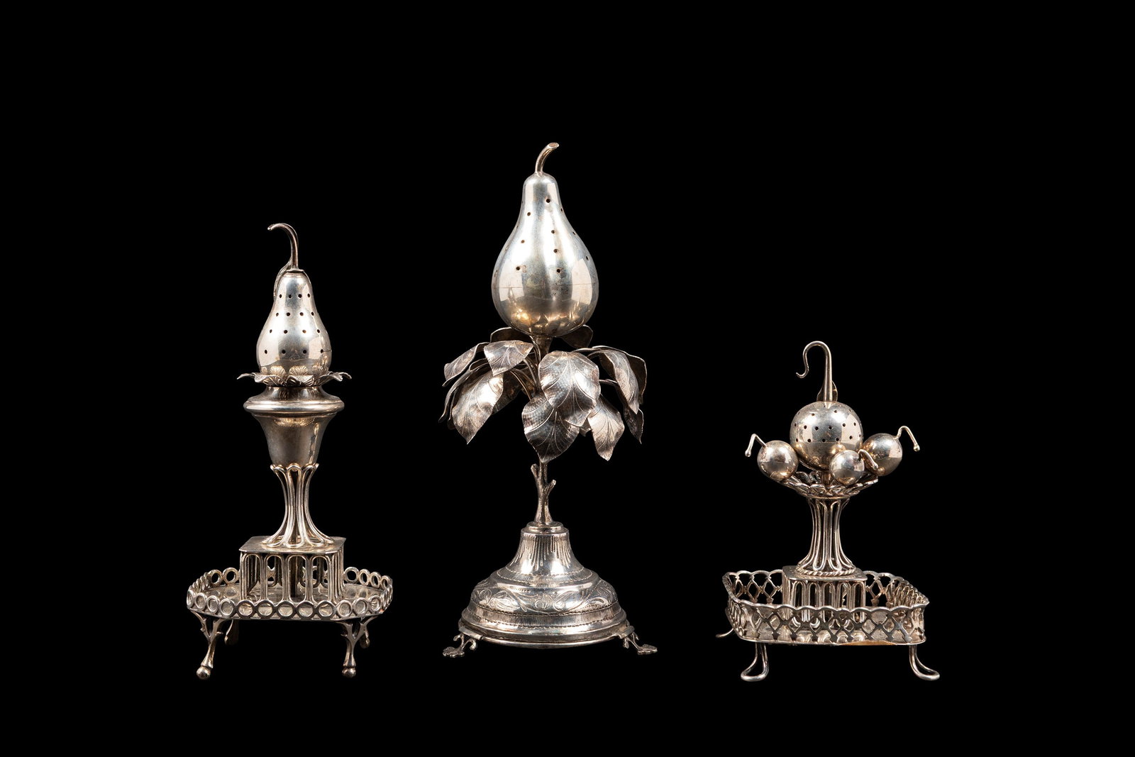 THREE SILVER TOOTHPICK HOLDERS, Portugal, early 20th century: The larger h cm 22.Spun and finely shaped in the form of fruit, they are enriched with elegant chased foliate motifs that enhance their naturalistic decoration. Bearing hallmarks of the city of Porto.