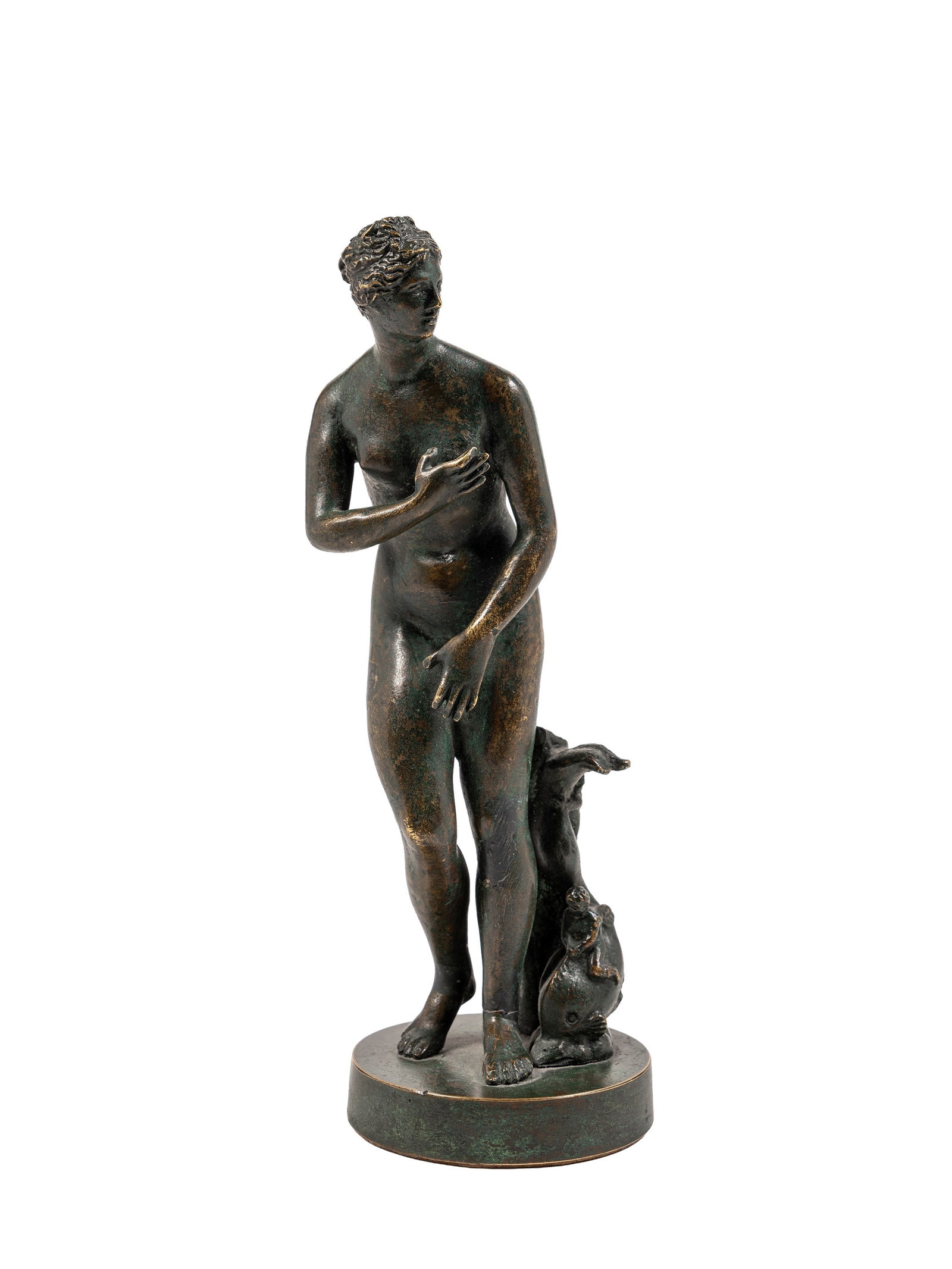 MEDICIAN BRONZE STATUES OF VENUS, 19th century: h cm 20,5.A nude goddess, standing next to a dolphin with two cherubs, on a circular base with a characteristic dark green/black patina.