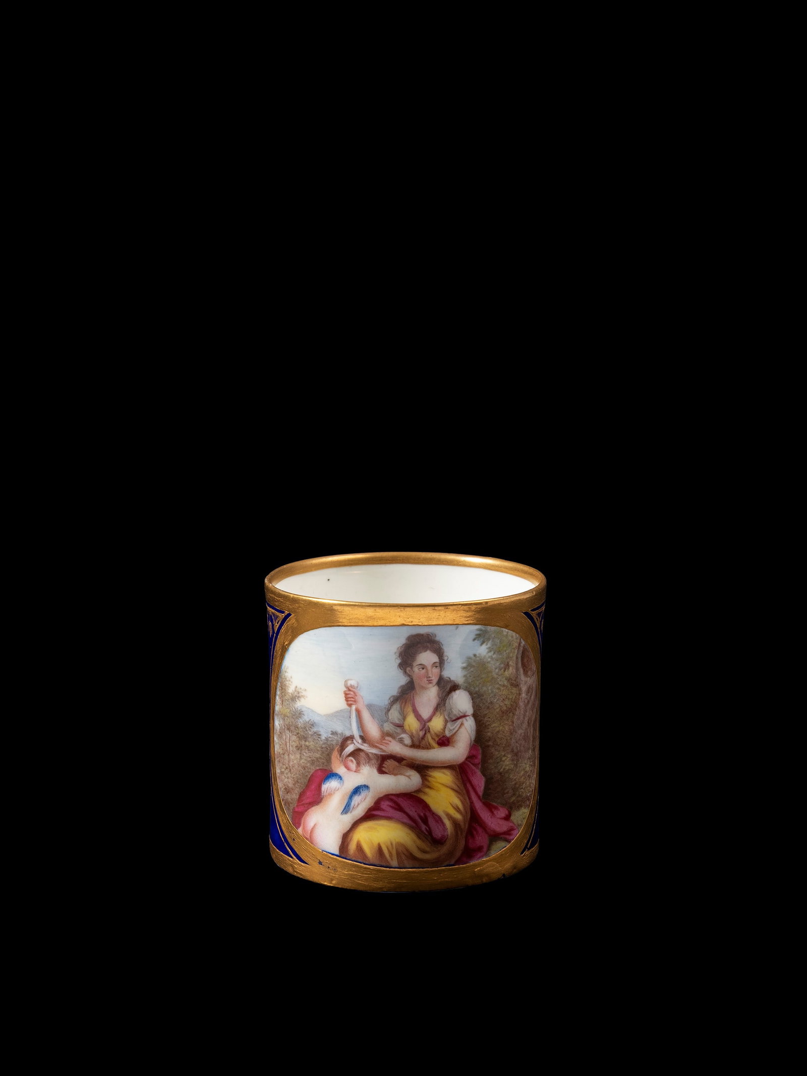 PORCELAIN CUP, Sèvres, 18th century: h cm 7.Against a cobalt blue background with gold decoration, centred on a scene featuring a blindfolded Cupid.