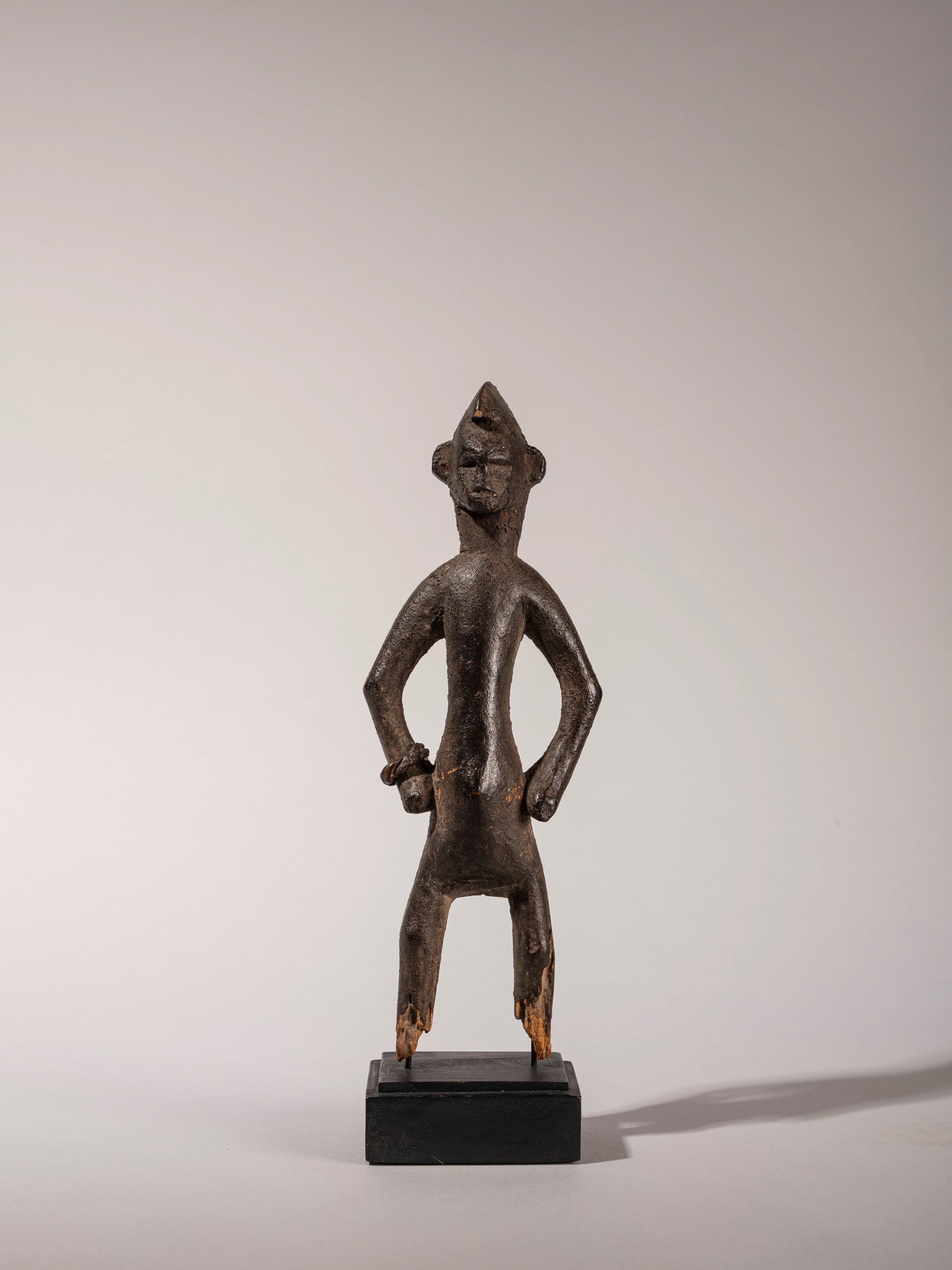 SENUFO SCULPTURE,: h cm 24 Depicting a male figure wearing a bronze bracelet.Provenance: Formerly in the Jean Cadenat collection.Accompanied by an expertise report by Dr. Beppe Berna.