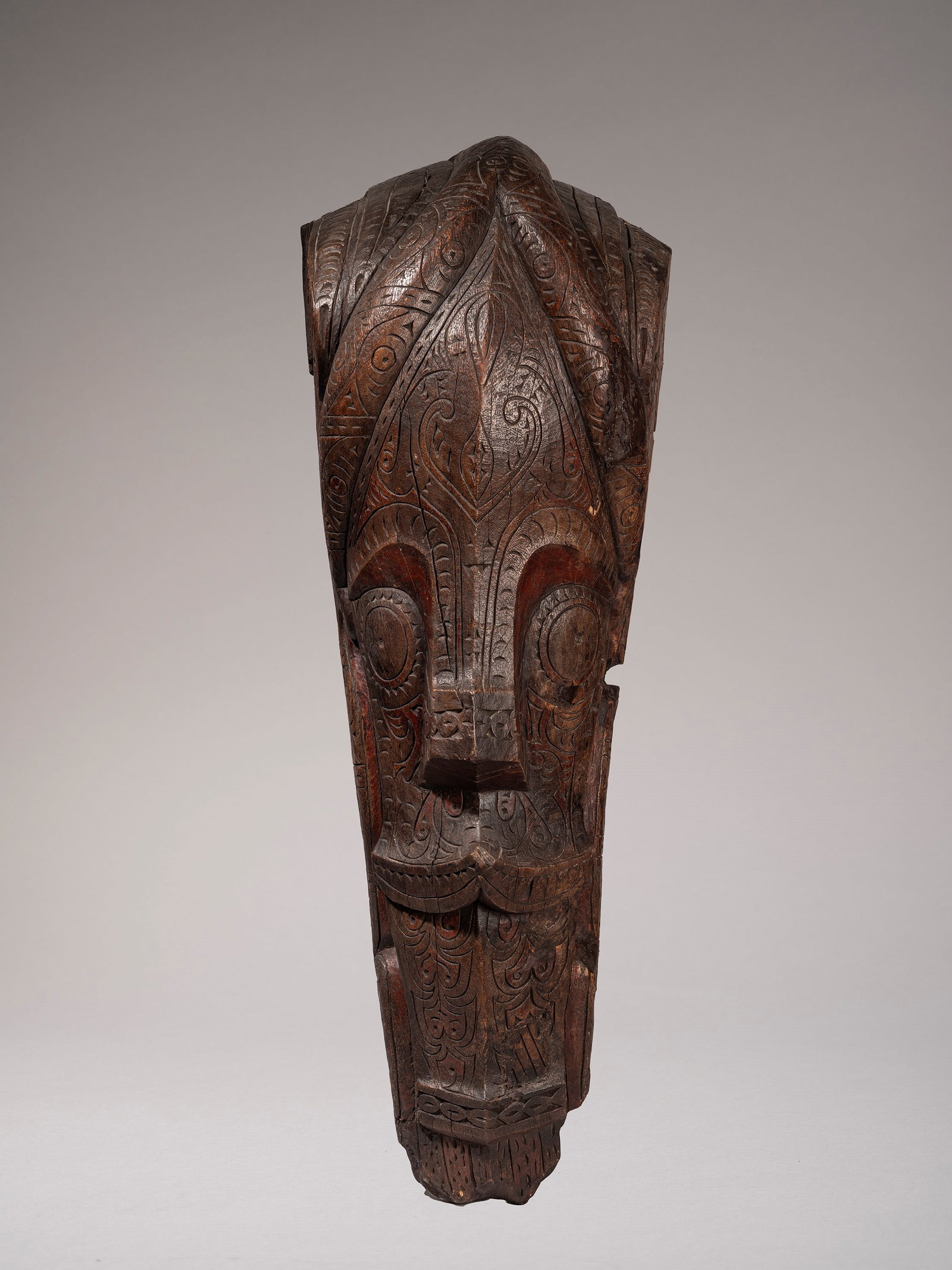 BATAK HOME DECOR, Batak. Sumatra: h cm 96 Carved in the shape of a lion’s head, the stylised face is characterised by large, round eyes; the entire surface is carved with geometric patterns. Traces of polychromy. Period repair. Prov