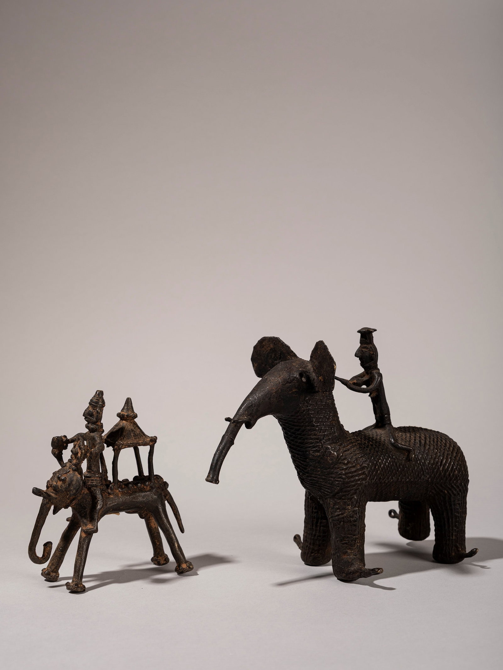 A LOT COMPRISING TWO BRONZE KOND SCULPTURES, South India, 19th/20th century: h max cm 15 Depicting figures on elephants.Provenance: Renzo Freschi Collection, Milan.