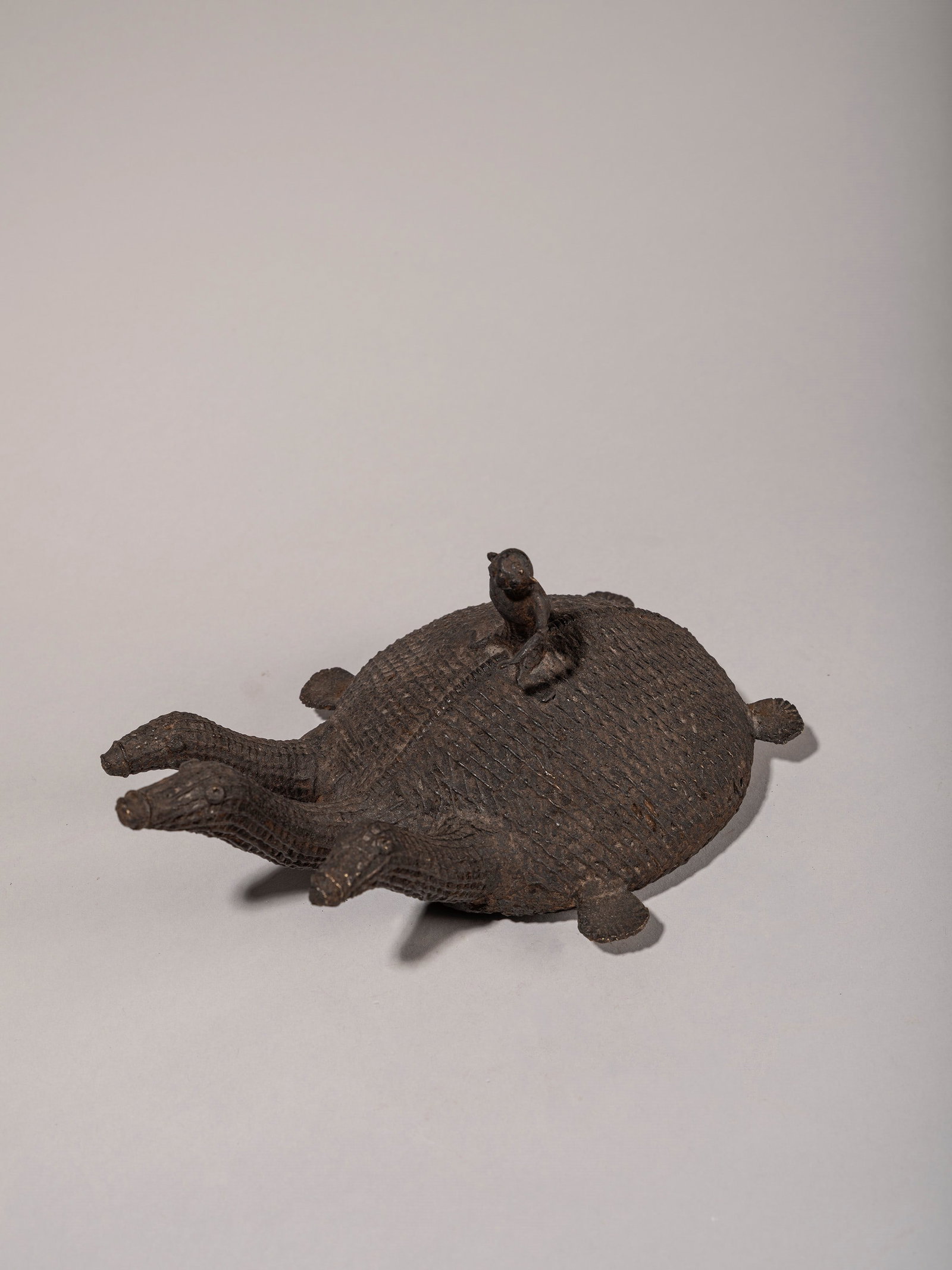 A THREE-HEADED BRONZE KOND FIGURE DEPICTING A TURTLE WITH A FIGURE ON ITS BACK, India, 19th/20th: l cm 25 Provenance: Renzo Freschi Collection, Milan.