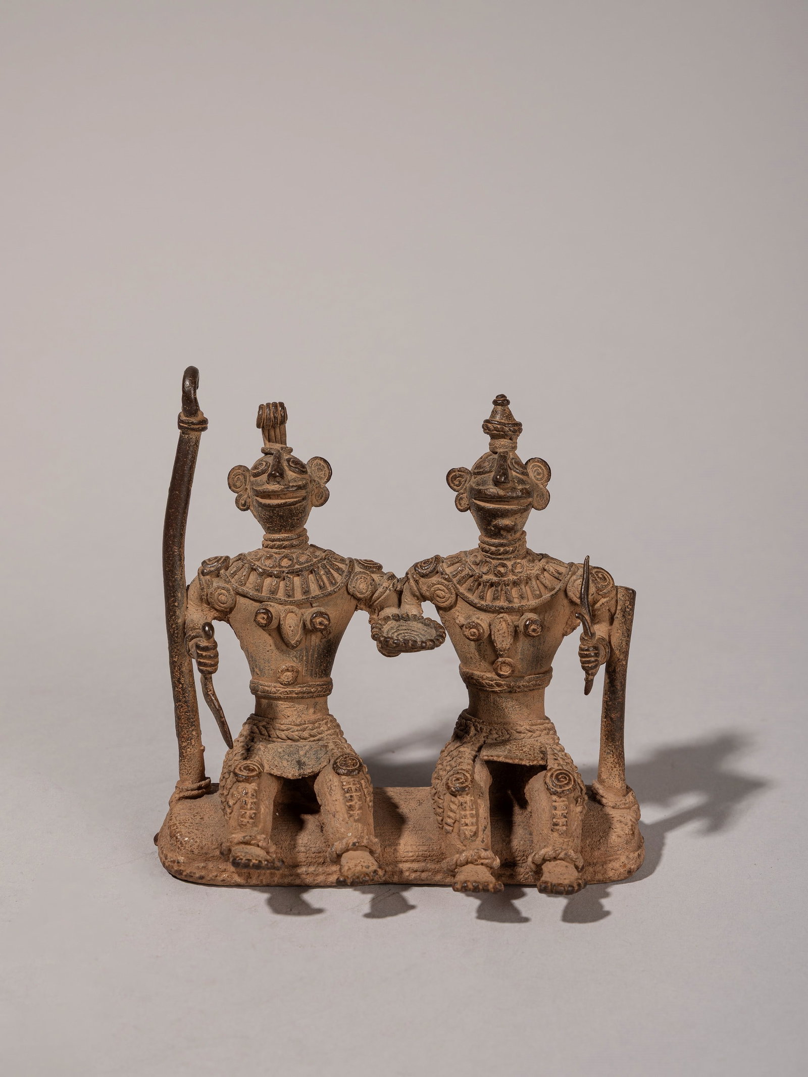 A BRONZE SCULPTURE DEPICTING TWO SEATED FIGURES, BASTAR STYLE, (1 of 2)