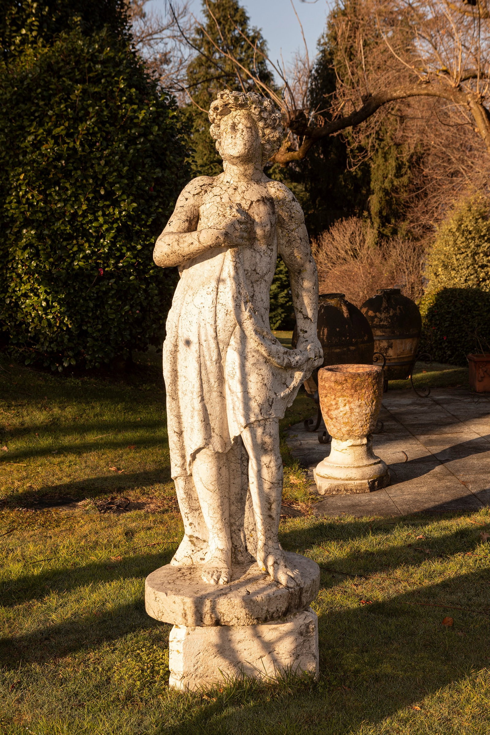 §A ISTRIAN STONE SCULPTURE DEPICTING A LADY, 17th / 18th century: h cm 150 The figure stands in a pose recalling the classical contrapposto. A soft drapery encircles the waist, falling along the legs in vertical folds, while one hand is raised to the chest to hold t