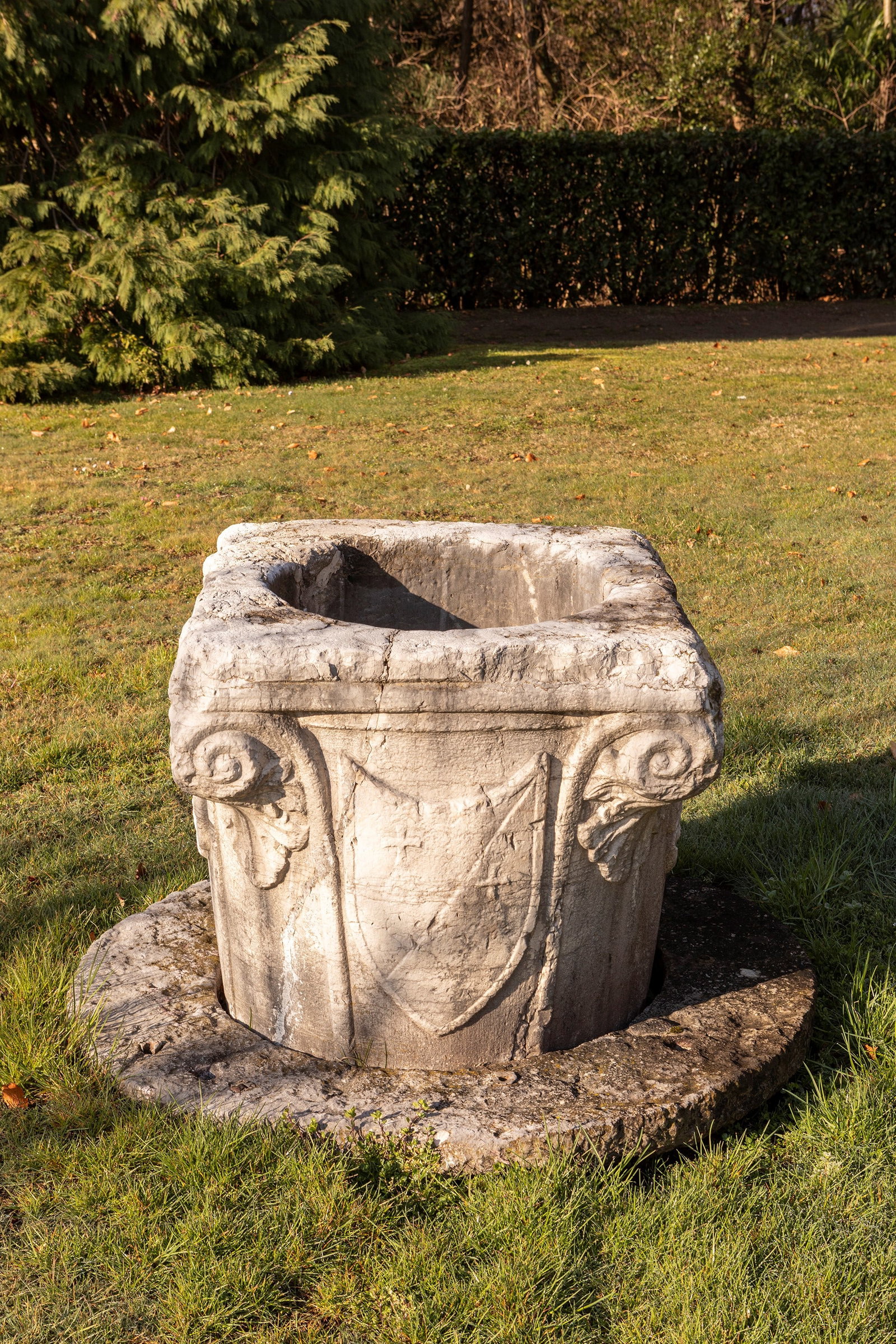 §A VENICE CARVED ISTRIAN STONE WELL-HEAD, Venice, late 15th century: h cm 78 x l cm 78 Shaped like a composite Corinthian capital, the structure features a molded circular base supporting a cylindrical shaft that widens toward the square top. At the four corners stand 