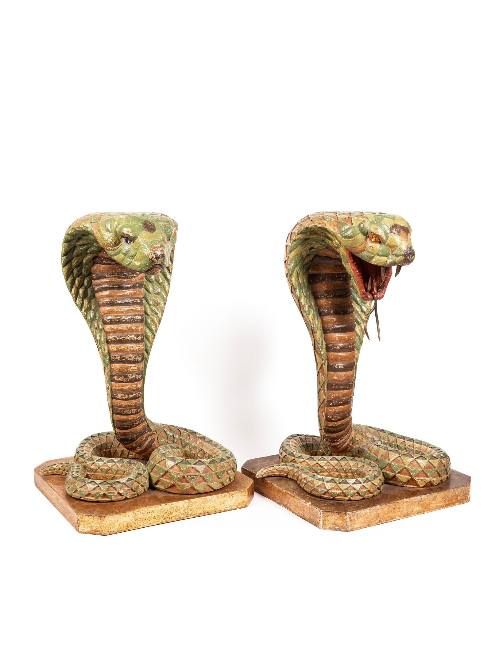 PAIR OF LARGE LACQUERED WOODEN COBRAS, Late 19th century: h cm 63 x l cm 40 Eclectic pair of sculptures depicting two cobras in a defensive posture, finely carved in wood and finished with a vibrant polychrome lacquer. The surfaces are decorated with a geome