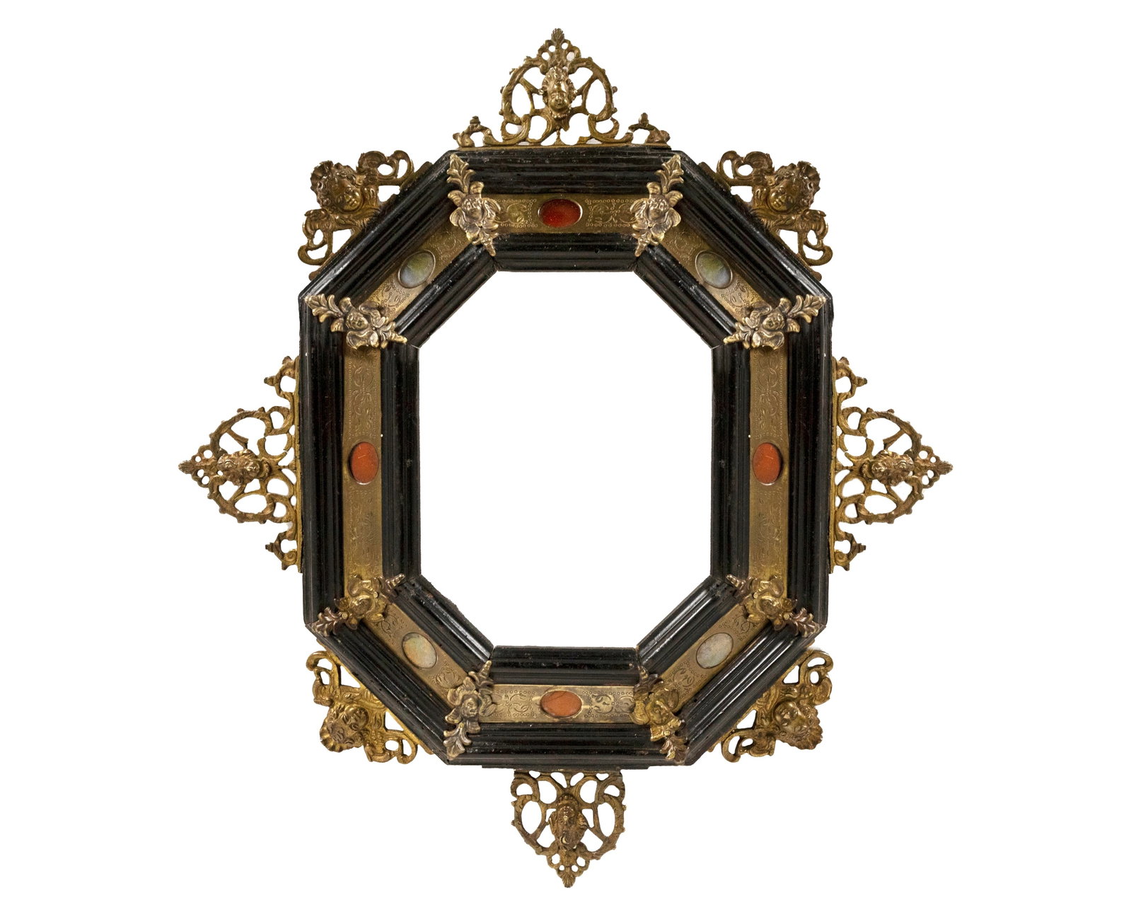 °OCTAGONAL FRAME IN EBONIZED WOOD, BRONZE AND HARD STONES, 19th century: h 43 cm × w 38 cm (overall); h 18 cm × w 14 cm (viewing window) Decorated with Putti Heads and Mascarons.