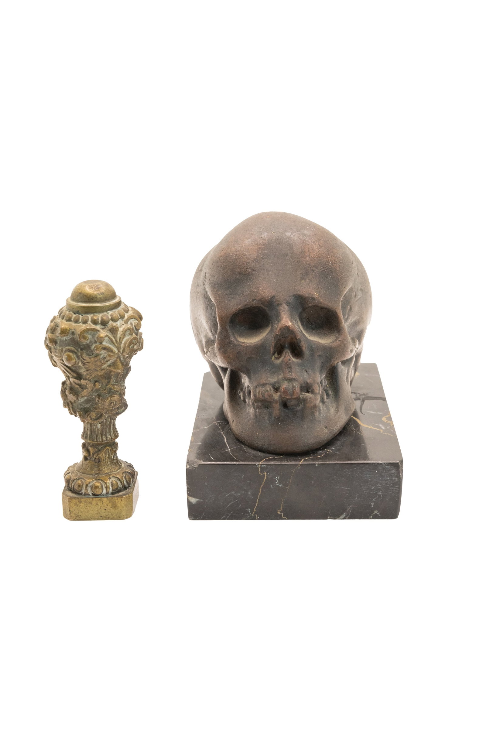 °A LOT CONSISTING OF A PATINATED PLASTER SKULL ON A PORTORO MARBLE BASE AND A BRONZE SEAL, The 20th: h 9 cm × l 7 cm × p 10.3 cm (skull); h 7.2 cm Under the seal monogram EG.