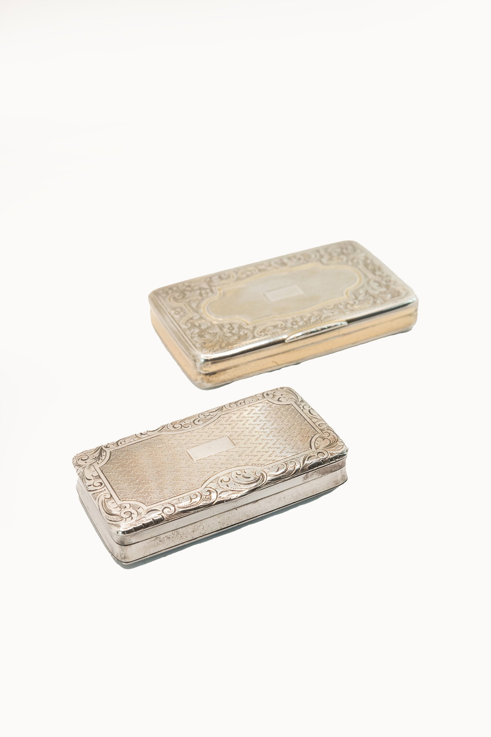 °TWO CHASED SILVER SNUFF BOXES, 19th century.: h cm 1,2 x l cm 8,3 p cm 4,7; h 1,2 x l cm 3,7 x p cm 6,9 Silver marks illegible.Weight: 118 g