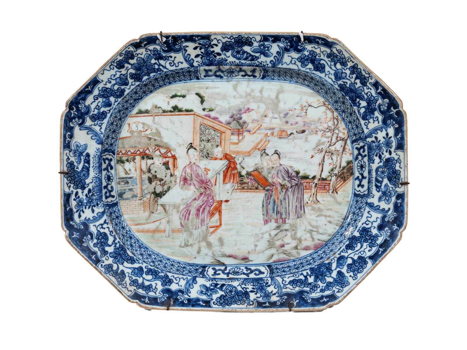 AN OCTAGONAL FAMILLE ROSE PORCELAIN PLATE, Cina, Canton, 18th century: l cm 41 The central scene depicts a view of the Hongs in the background, while in the foreground a tree-lined courtyard hosts a lady and four children engaged in play. The border is decorated in under