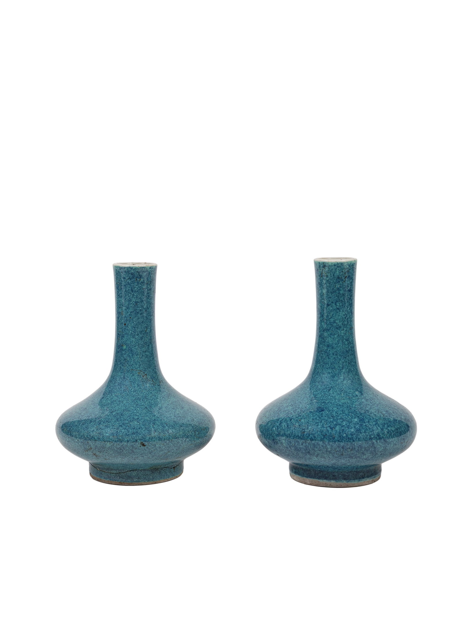 A PAIR OF ROBIN'S EGG BOTTLE-SHAPED VASES, China, Qing dynasty, 19th century: The larger h cm 12,5 They are covered with an opaque glaze in shades of turquoise and bluish-violet. On the base they bear an apocryphal six-character underglaze blue mark of the Kangxi Emperor.&