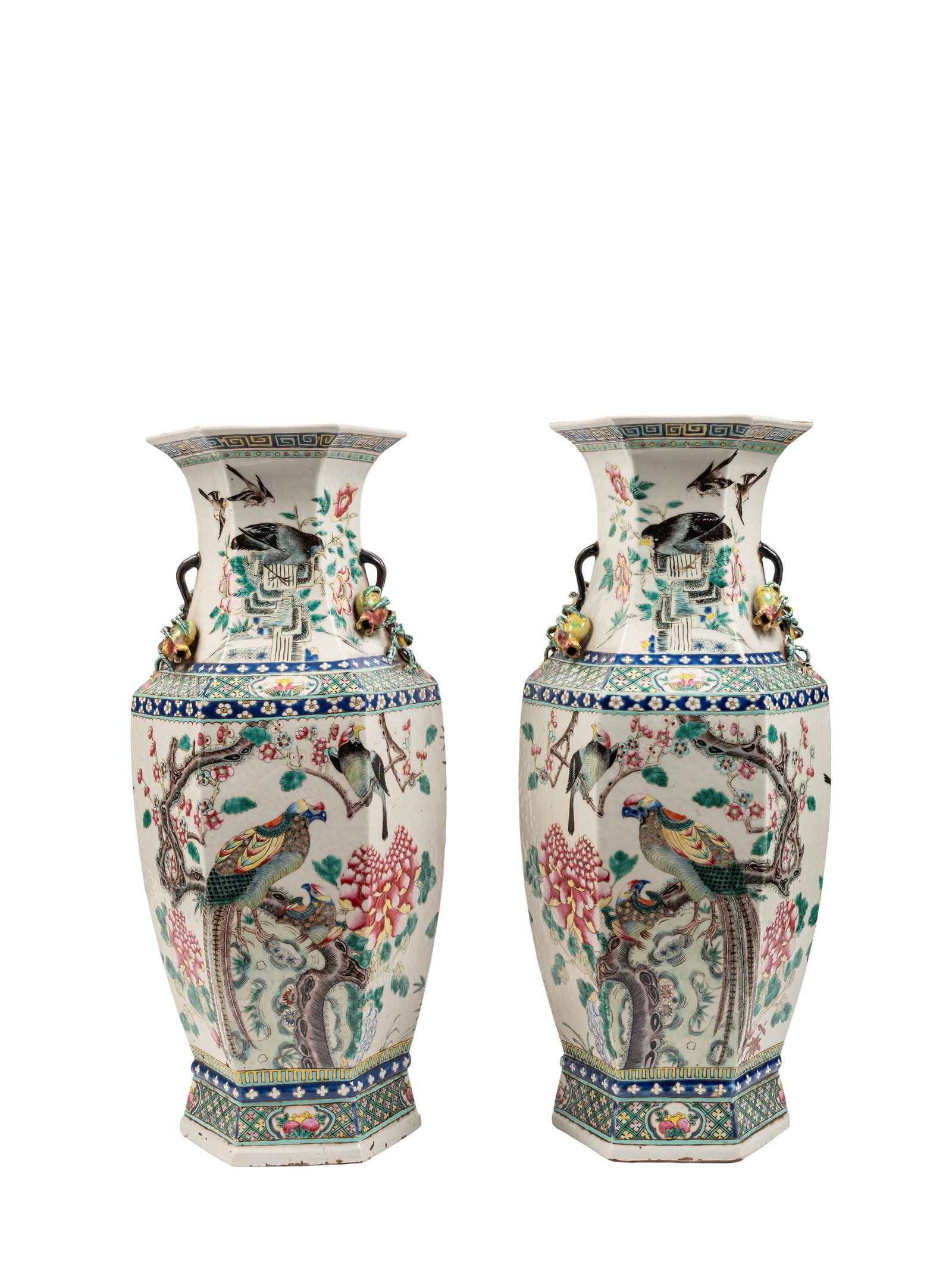 A PAIR OF LARGE FAMILLE ROSE BALUSTER-SHAPED PORCELAIN VASES, China, Qing dynasty, 19th century: h cm 58 With hexagonal section, they feature two bands decorated with geometric motifs and floral reserves framing the main scene, animated by birds in flight within a lush garden of cherry, peach, an