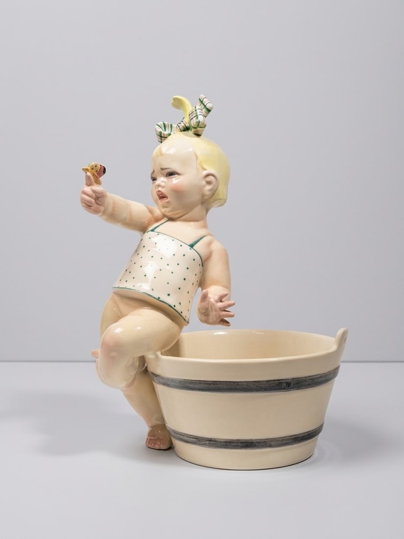 Sandro Vacchetti (Carrù 1889 - 1974), "GIRL WITH BUTTERFLY" SCULPTURE, circa 1934: h cm 38,5 x d cm 27 Slip-cast earthenware. Model no. 404. Manufacturer's mark and decorator's symbol (Camillo Ghigo) to the underside. Signed "S. Vacchetti" to the side of the tub. Produced by Lenci,