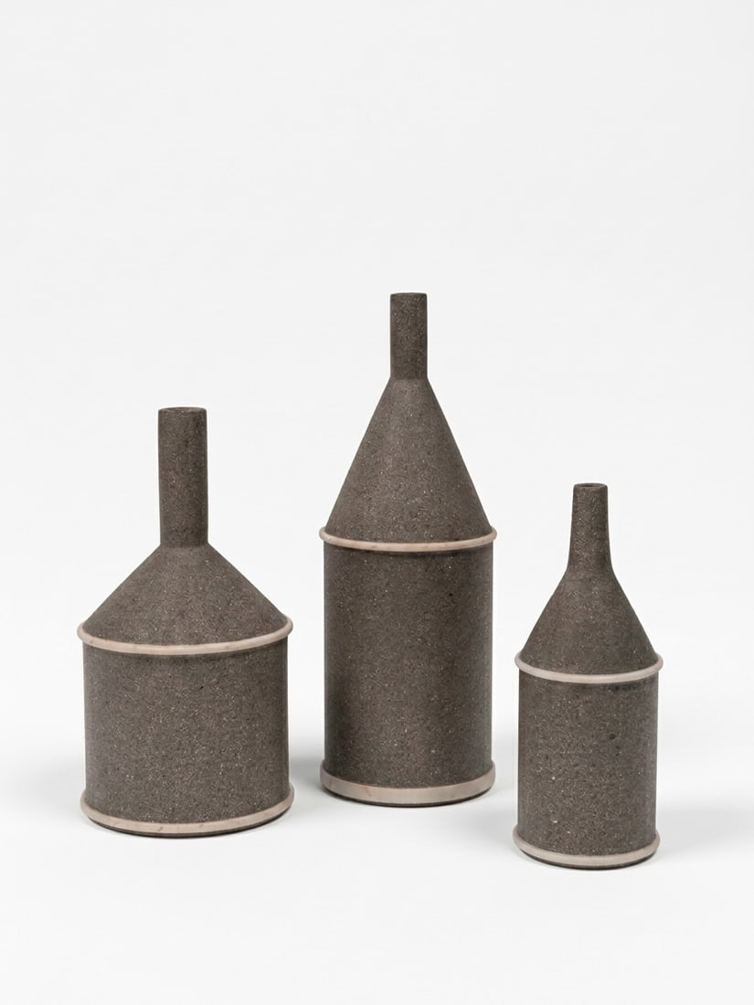 Giulio Lazzotti (Pietrasanta 1943 - 2024), JUG-SHAPED VASES, 1980: From h cm 21 to 24.5 x d cm 8 to 12.5 Set of three. Pietra serena sandstone and marble, Mageia production, Italy.