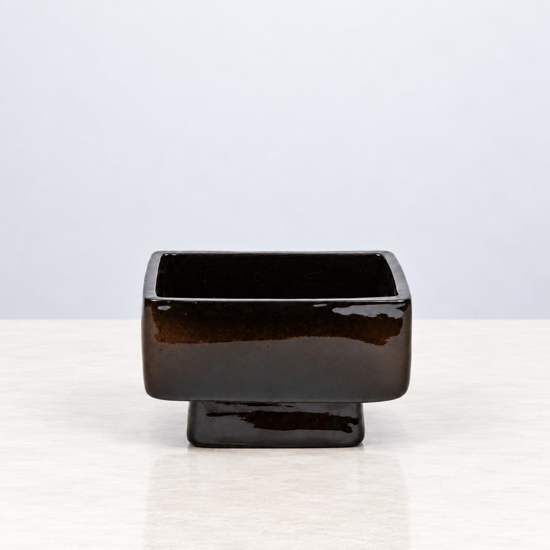 Franco Meneguzzo (Valdagno 1924 - 2008), RECTANGULAR BOWL, 1959: l cm 15,5 x h cm 9 x w cm 13,5 Glazed earthenware, on a dark brown truncated-pyramid-shaped foot. Danish workshop; the manufacturer’s mark, ‘Meneguzzo’, and an initials are stamped on the revers