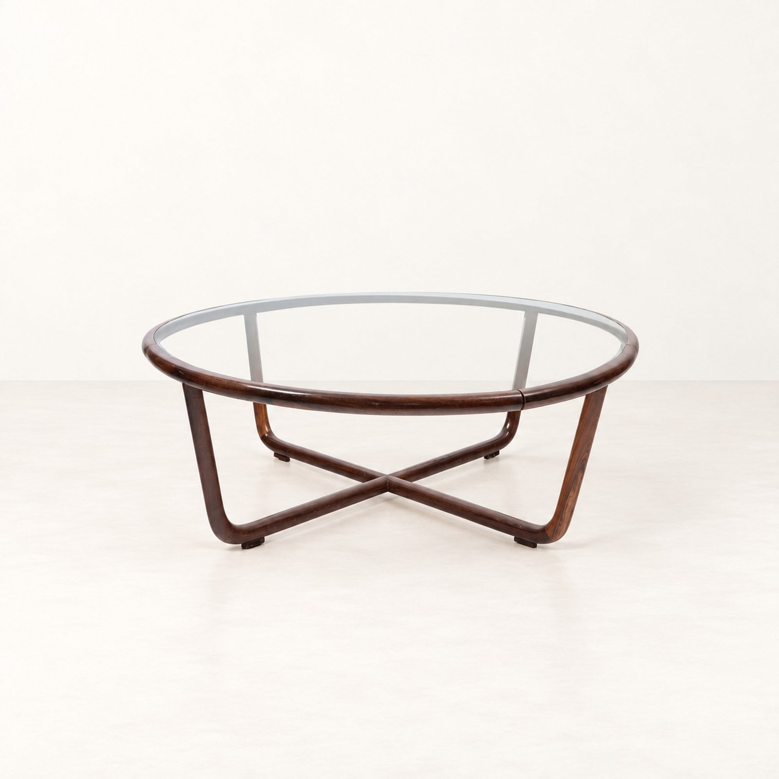 Joaquim Tenreiro (Melo 1906 - 1992), "MESA DE CENTRO" LOW TABLE, circa 1950s–60s: h cm 34 x d cm 100 Curved solid wood with circular glass top. Designed by Joaquim Tenreiro, Brazilian production.