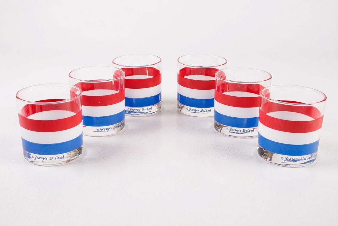 Set of 6 Georges Briard MCM Rocks Glasses in Red, White, and Blue: By Georges Briard, this matched set of six mid-century modern lowball rocks glasses is decorated throughout with eye-catching stripes of red, white, and blue. Each glass exhibits the maker's