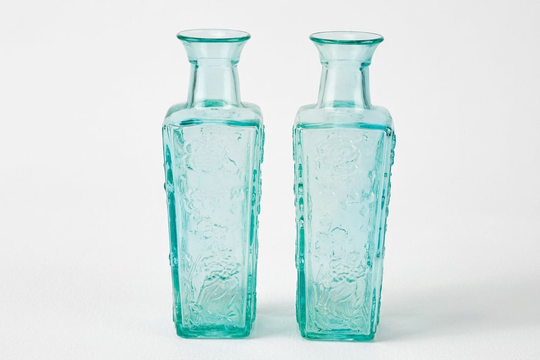 Pair of Vintage MCM Vase Bottles in Teal Glass: Pair of vintage MCM teal glass vase bottles.? They have square bodies and raised floral patterns on all sides.? Nice solid thick glass.? Good condition, great for flowers or just accent pieces for