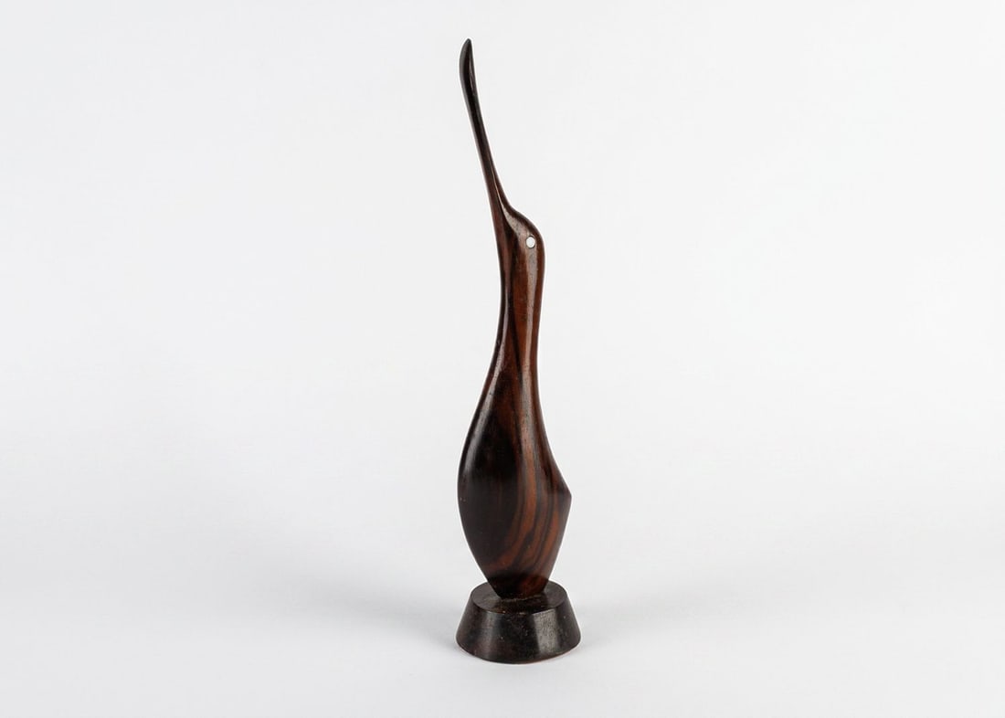 MCM Wooden Sculpture of a Spoonbill: Hand carved, this wooden sculpture depicts a spoonbill bird with a sleek form that is perfectly designed for mid-century modern settings. This sculpture is unsigned by the unknown artist and is in