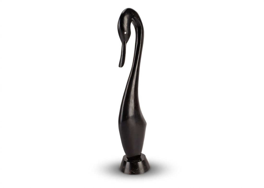 Vintage MCM Wooden Sculpture of a Swan: Hand carved from a dark hardwood, this vintage mid-century modern sculpture depicts a swan elegantly rendered with a sleek and curvaceous form. This sculpture is unsigned by the unknown artist and is