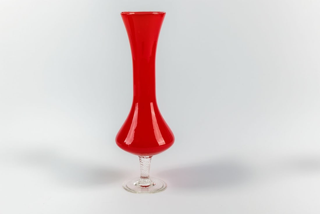 Vintage MCM Murano Style Bud Vase in Ruby Red Art Glass: Dated vintage, this Murano style bud vase is crafted from stunning ruby red art glass and features a shapely body that resolves in a clear, twisted stem and pedestal base. In good condition, with some